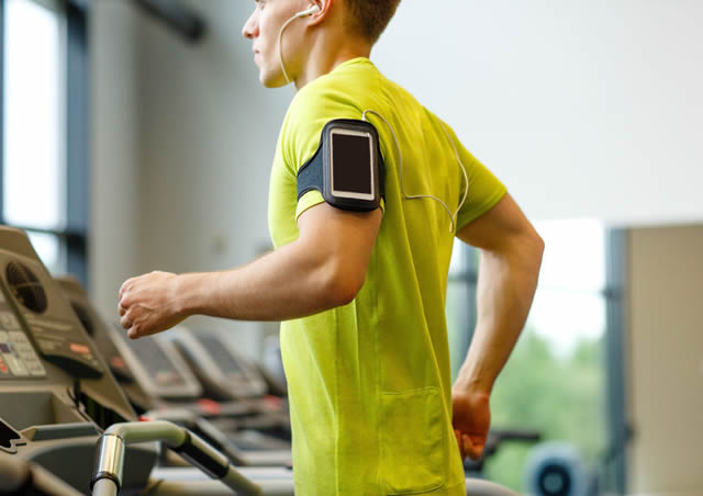 Man running on treadmill with headphones.