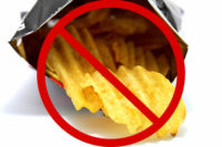 Open bag of potato chips with circle and bar "no" symbol superimposed.