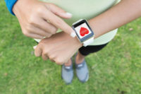 Woman checking heart rate on smart watch after exercising.