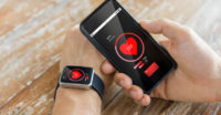 Man using heart rate phone apps and fitness watch.